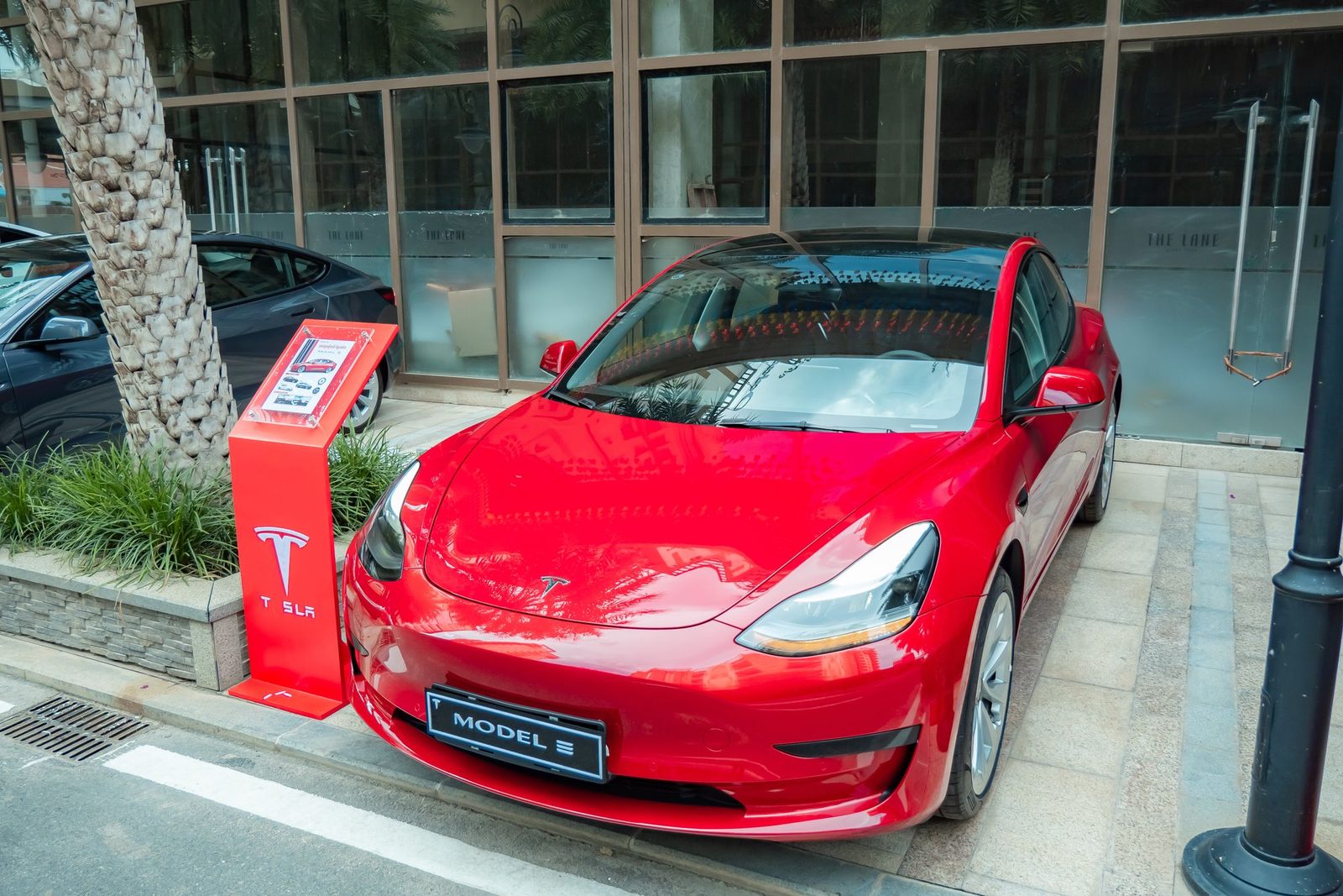 Red Tesla Model 3 parked on a city street